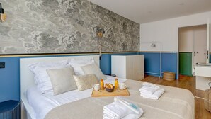 Ein modernes Hotelzimmer mit einem großen Bett, einem Frühstückswagen und einem Kleiderschrank.