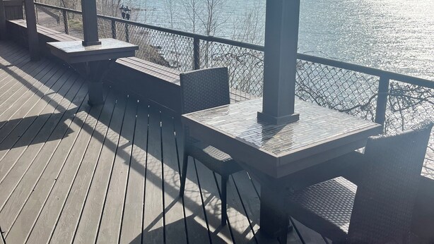 A wooden deck with a table and chairs, overlooking a body of water. - Location and panoramic lake views will make for an unforgettable experience.  (Duluth)