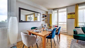 A dining area with a wooden table, blue chairs, and a mirror on the wall. - 825 Suite Bacla - Superb apartment (Courbevoie)