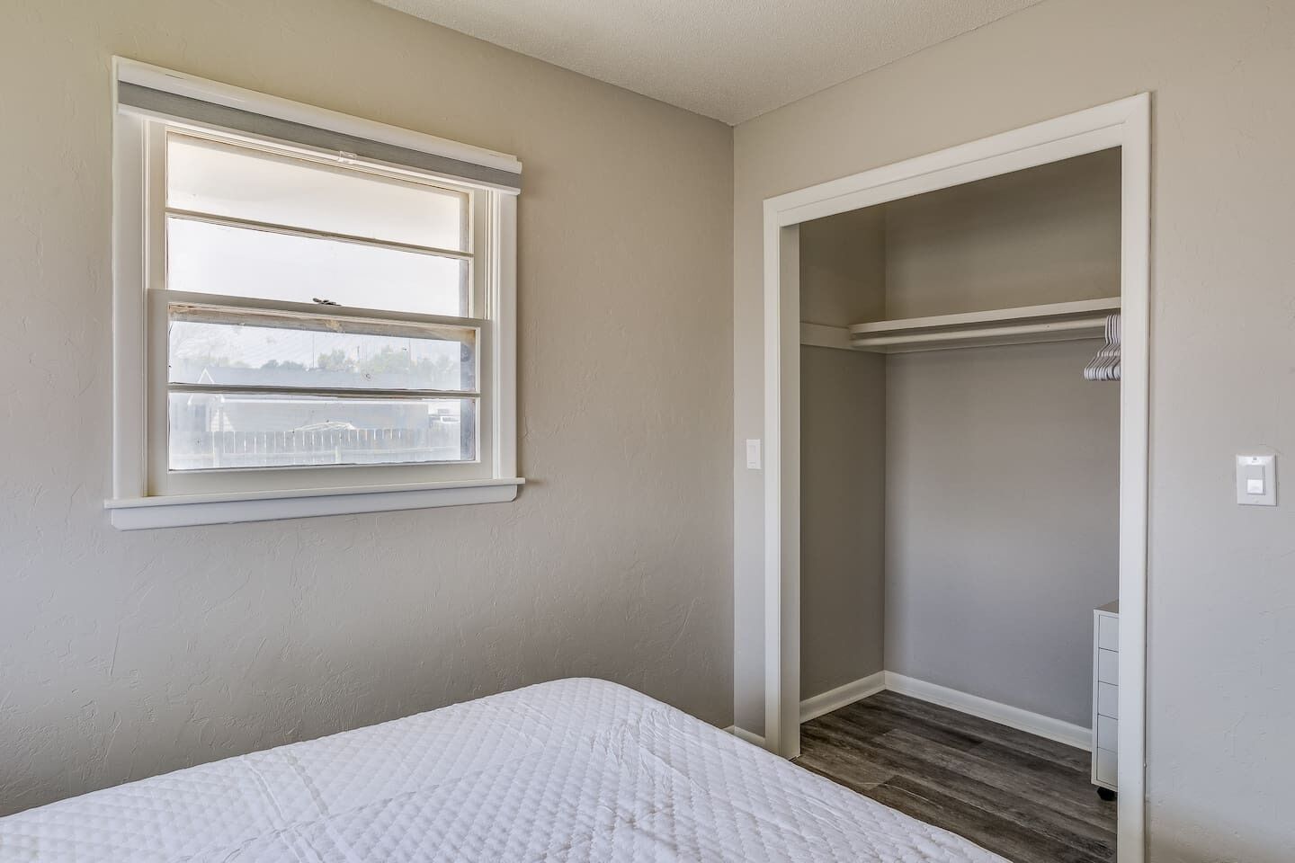 A bedroom with a bed, a window, and a walk-in closet.
