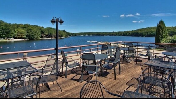 Une terrasse avec des sièges extérieurs donnant sur un lac.