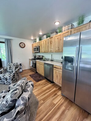 A modern kitchen with wooden cabinets, stainless steel appliances, and a built-in dishwasher.