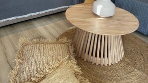 A bedroom with a bed, a wooden wardrobe, a sofa, a round coffee table, and a woven rug. - CACTUS SUPERB SUITE WITH PRIVATE POOL AND STUNNING SEA VIEWS (SKIATHOS)