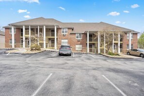 A multi-story building with a parking lot in front. - Eagle's Nest at The Club- Chic 2BR Golf View Condo (Branson)