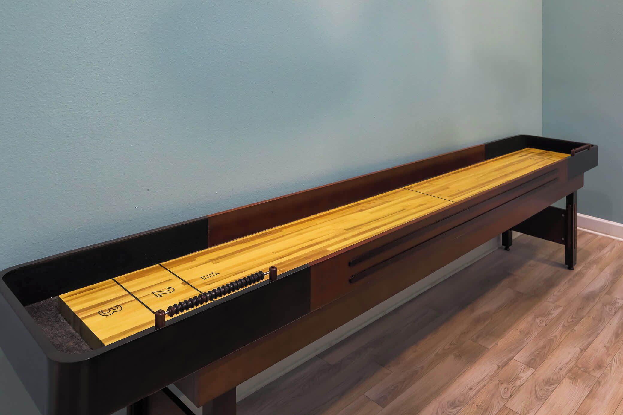 A wooden bench with a built-in shuffleboard table.