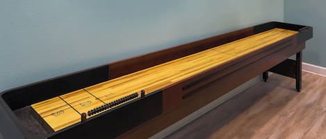 A wooden bench with a built-in shuffleboard table.