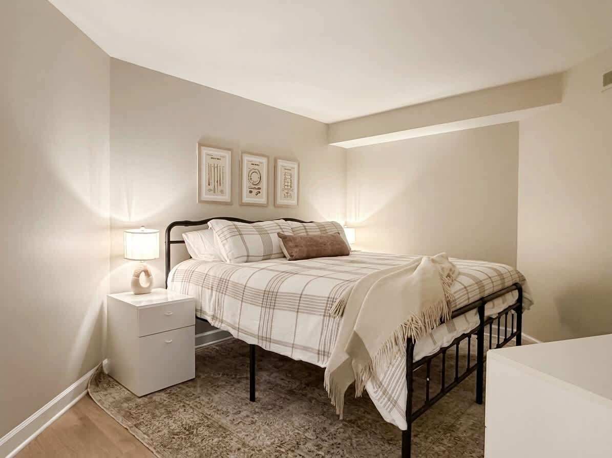 Une chambre à coucher avec un lit, une table de chevet et des œuvres d’art murales.