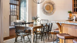A dining area with a wooden table, black chairs, and a chandelier. - Penthouse 7 on Taneycomo - Chic Waterfront Condo! (Branson)