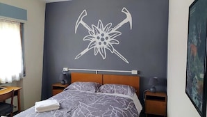 Una camera da letto con un letto, due comodini, una testiera e un elemento decorativo a parete.