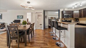 Een moderne keuken met donkere houten kasten, een stalen magnetron en een inbouwoven.