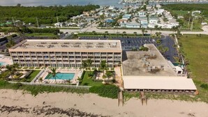 Um hotel grande com vários andares, piscina e área de praia.