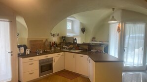 A kitchen with a central island, wooden flooring, and a window providing natural light. - 2 Bedroom Apartment in Gionghi-cappella (Gionghi-cappella)