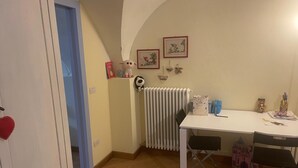 A small room with a white table, two chairs, a radiator, and a door. - 2 Bedroom Apartment in Gionghi-cappella (Gionghi-cappella)