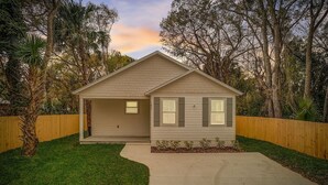 A single-story house with a front porch, a garage, and a small front yard.
