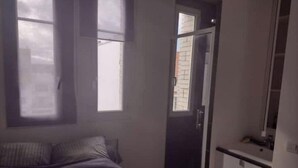 Ein Schlafzimmer mit Bett, Kleiderschrank und Fenster.