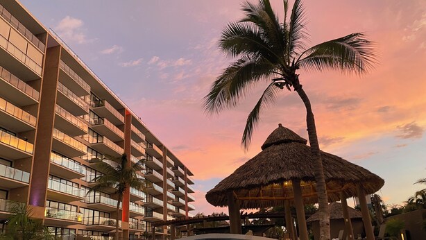 A hotel with a swimming pool, palm trees, and a sunset sky. - En el mar la Vida es más Sabrosa y en Altamar Residencial más (Acapulco)