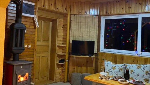 Ein gemütliches Zimmer mit Kamin, Fernseher und Essbereich mit gedecktem Tisch.