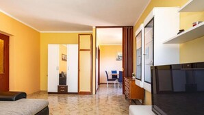 A hotel room with a bed, a TV, a desk, and a chair. - Two Bedroom Apartment with Terrace (Ugljan)