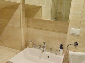 A bathroom with a white sink, multiple faucets, a mirror, and a towel rack. - Luxury Style Apartments - Comfort Studio (Royal) (Dubrovnik)