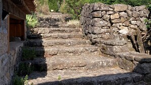 Una escalera de piedra que lleva a un edificio de madera con techo inclinado.