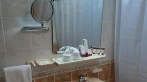 A bathroom with a sink, mirror, and shower curtain. - Ivory Hotel Apartment (Abu Dhabi)