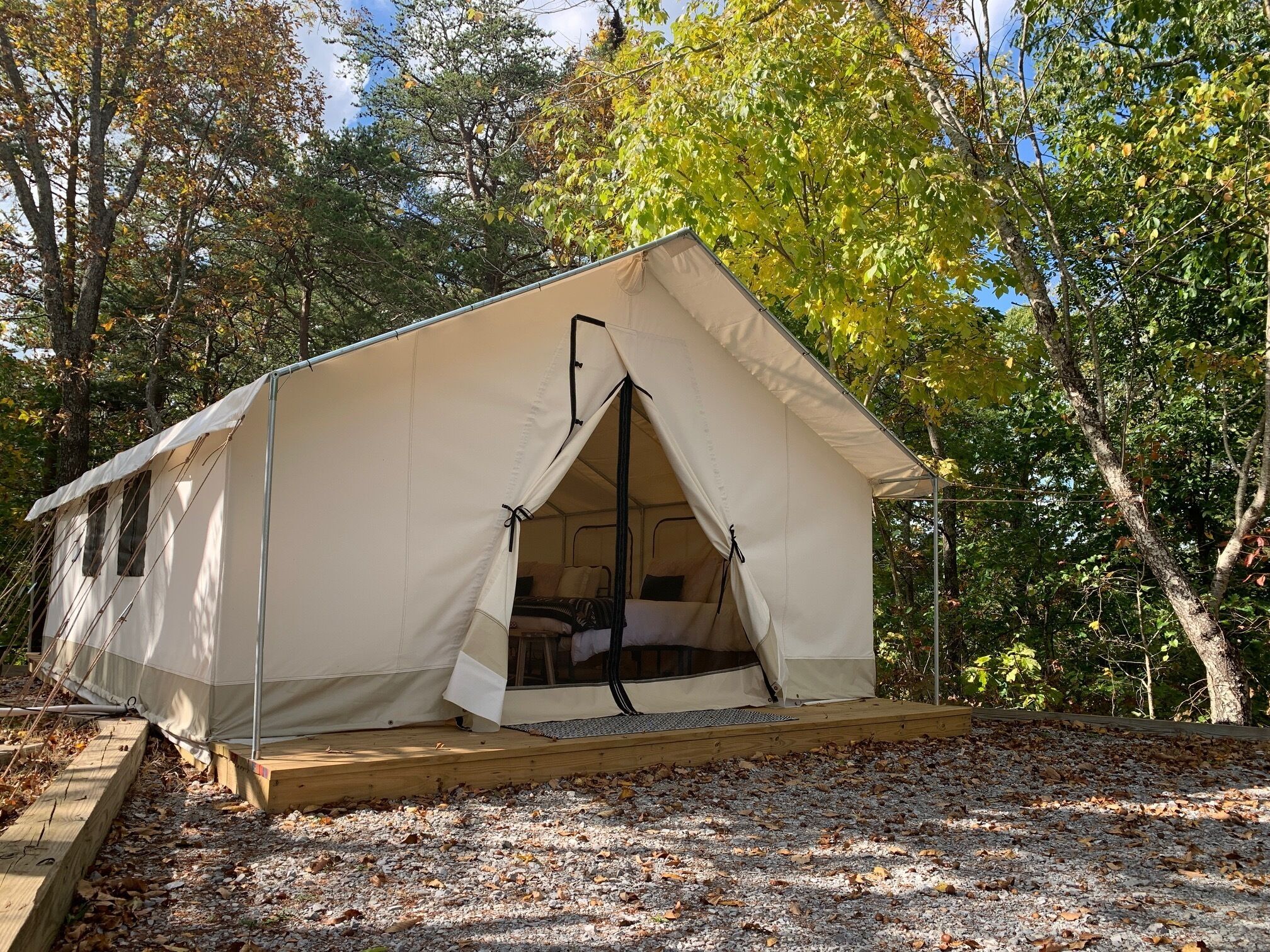 A single-story tent with a flat roof, a small porch area, and a window on the side.