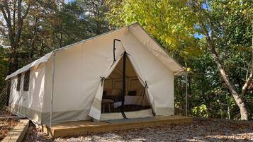 A single-story tent with a flat roof, a small porch area, and a window on the side.