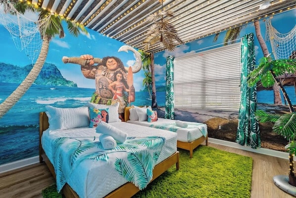 Una habitación con dos camas, un mural de paisaje tropical y vista al océano.