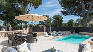 A pool area with a dining table, chairs, and a sofa. - Villa Hilary with private pool near Playa de Muro (Muro)