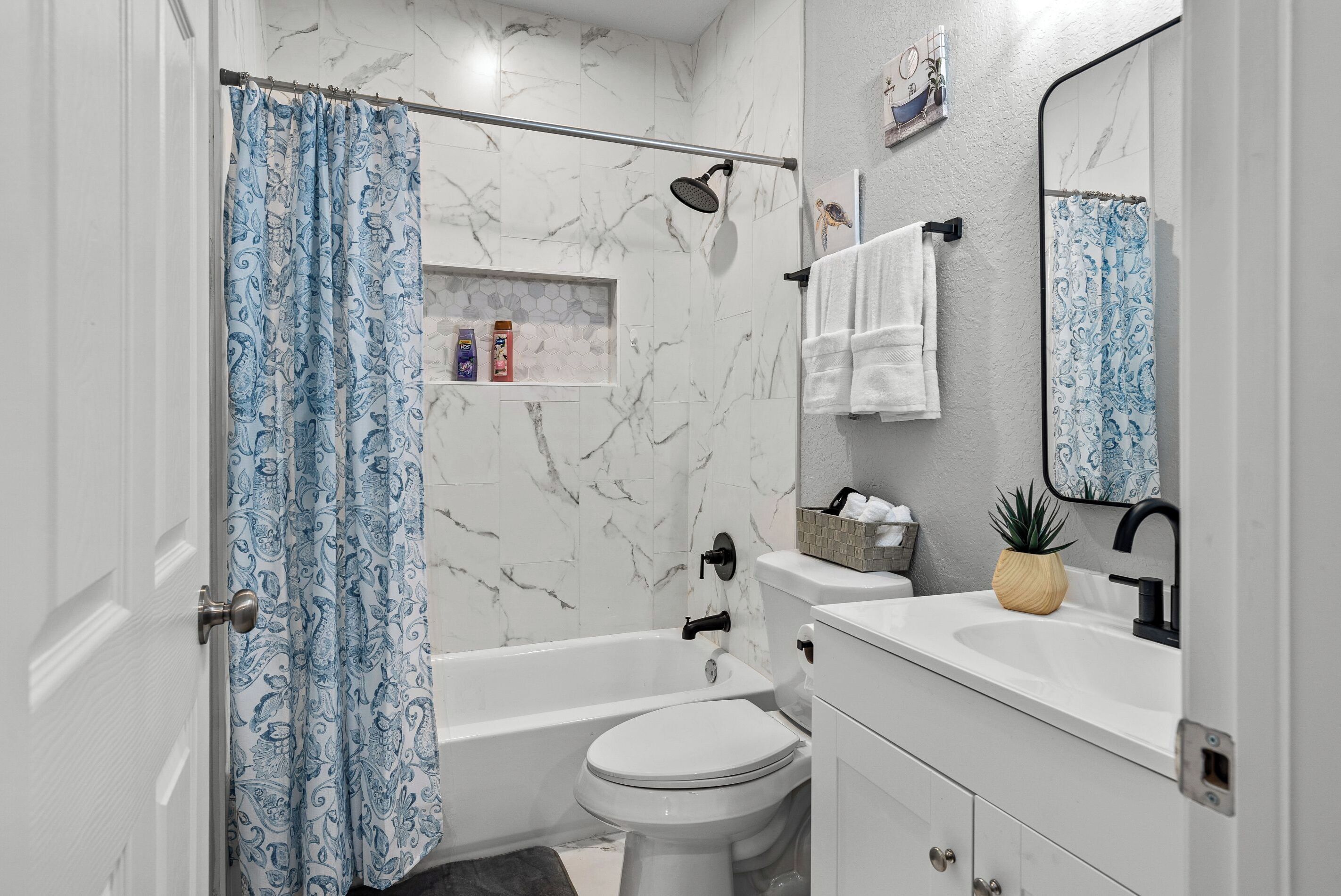 A bathroom with a bathtub, toilet, and sink.