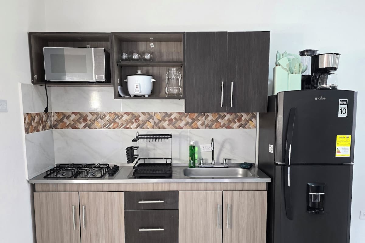 A modern kitchen with a microwave, stove, and refrigerator.