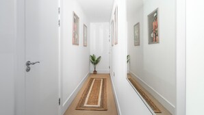 A narrow hallway with white walls, a brown carpet, and framed artwork. - 3 bedroom accommodation in Woolacombe (Woolacombe)