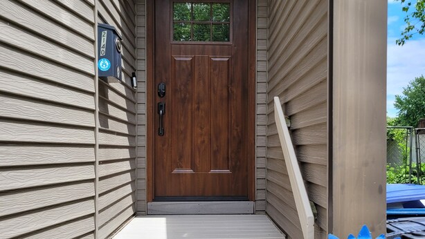 A wooden front door with a number plate, a mailbox, and a small porch with steps leading up to it. - Lake Channel 'Brewhaus' Townhouse: 2 bedrooms with 6 levels on Lake Winnebago (Oshkosh)