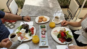 A table set for breakfast with plates of food, a coffee cup, and a juice glass. - Perge Pine Green (Antalya)