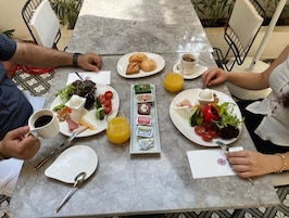 Una mesa lista para el desayuno, con platos de comida, una taza de café y un vaso de jugo.