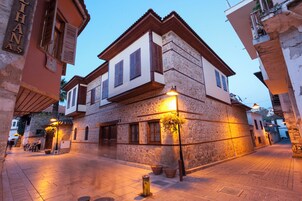 Un edificio de piedra con un balcón y un letrero que dice "THANAS".