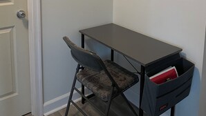 Ett hörnrum med ett skrivbord, en stol och ett förvaringsskåp under skrivbordet.