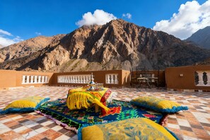 A terrace with a checkered floor, a table with a tray, and colorful cushions. - Le Reflet D'Imlil - Full Place (Imlil)