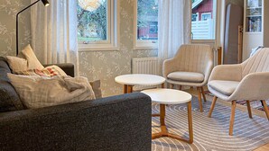 A cozy living room with a sofa, two armchairs, a coffee table, and a lamp. - Stunning home in Gotland with kitchen (Gotland)