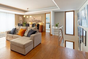 Ein modernes Wohnzimmer mit einer Couch, einem Essbereich und einer Treppe.