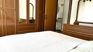 Un dormitorio con una cama grande, un armario de madera y un espejo.