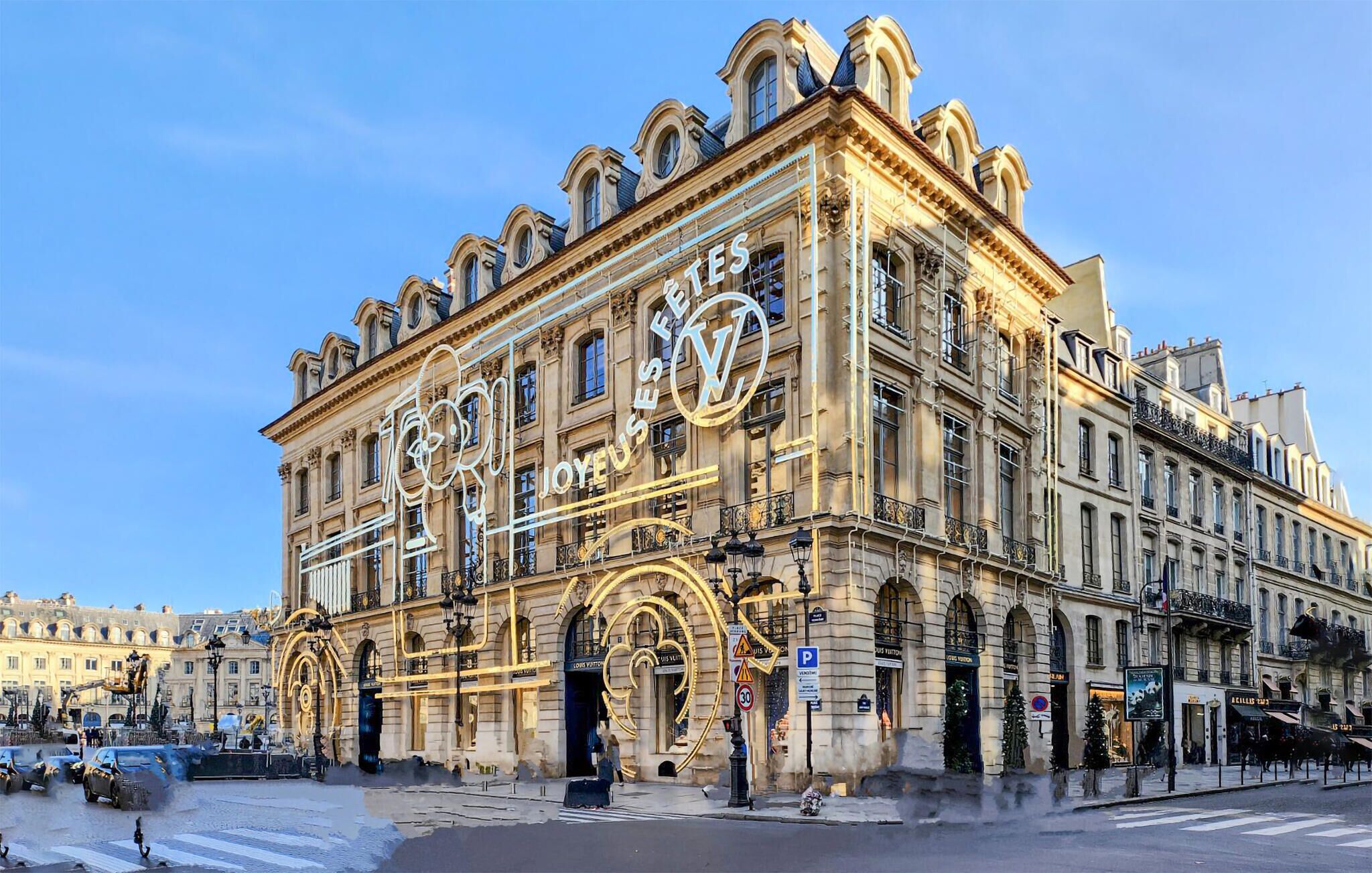 Un bâtiment historique à l’architecture riche et élaborée, doté de grandes fenêtres et abritant un magasin Louis Vuitton très visible.