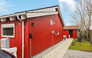 Un edificio rojo con un buzón, un ventanal pequeño y una puerta.