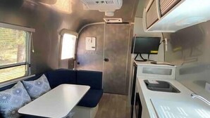 A compact kitchenette with a sink, stove, and countertop. - Airstream - 15 Minutes to Kings Canyon (Dunlap)