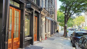 Un immeuble avec une enseigne indiquant « SSUITE. The Loxley » et un potelet d’incendie sur le trottoir.