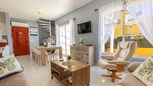 A living room with a sofa, coffee table, TV, and a staircase. - Cozy home in Mazarrón (Mazarrón)