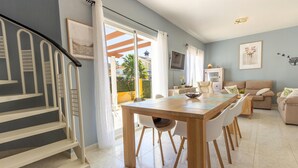 A modern living room with a dining area, a staircase, and a view of the outside. - Cozy home in Mazarrón (Mazarrón)