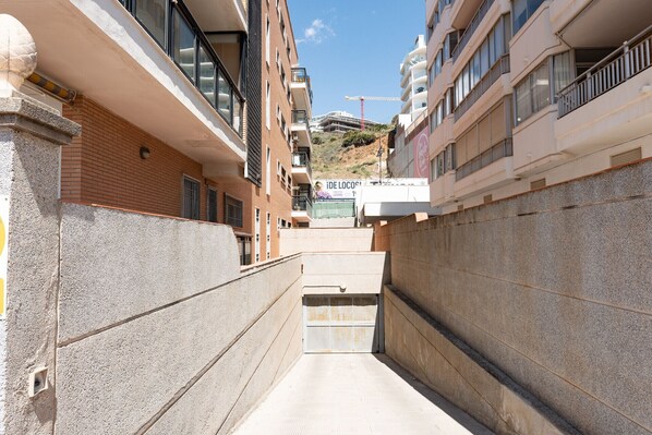 Une ruelle étroite entre deux bâtiments, avec une grue de construction en arrière-plan.