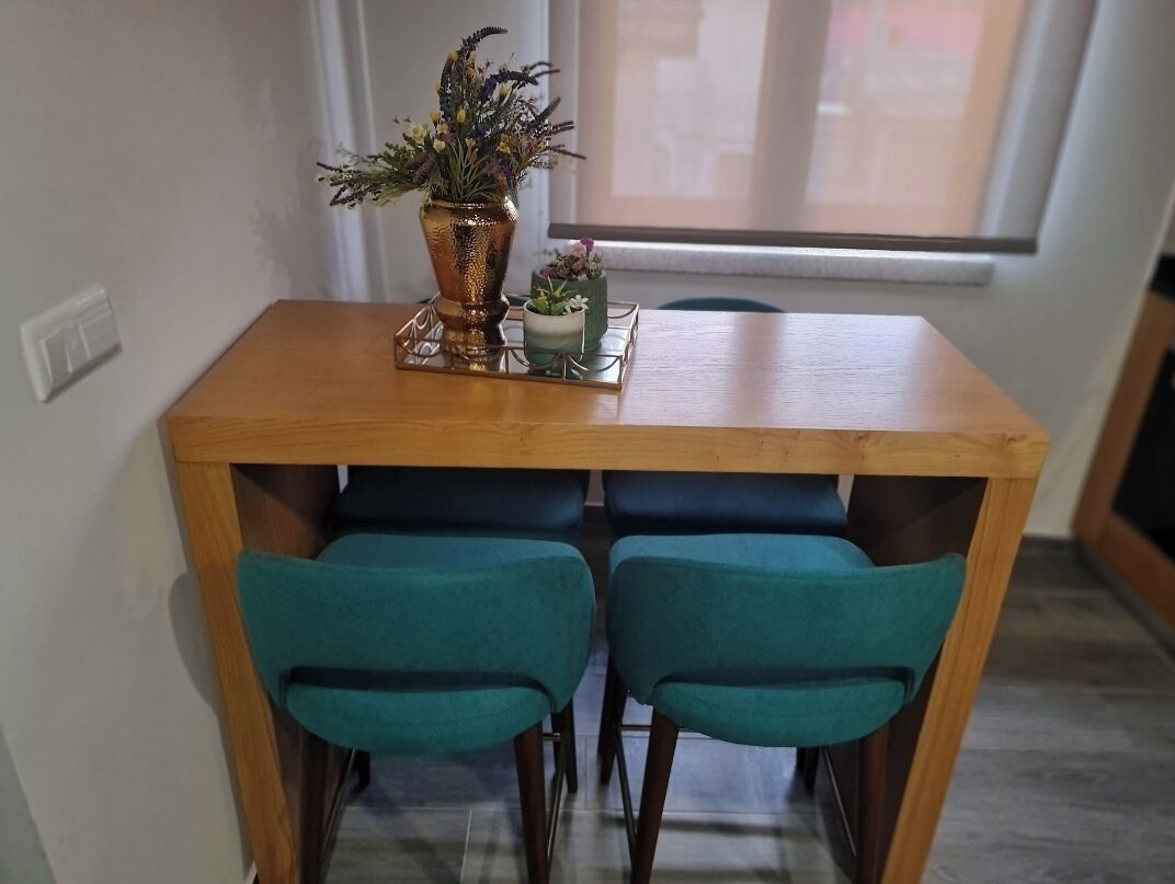 A dining area with a wooden table and two teal chairs.