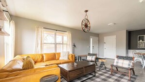 Ein Wohnzimmer mit Sofa, Couchtisch und Sesseln, einer Chandelier und einem Schachbrettmuster-Boden.